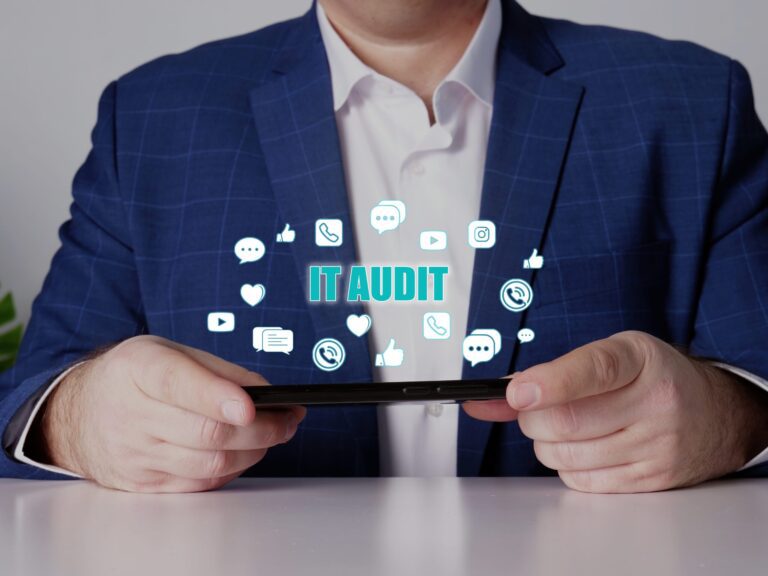 business man with tablet and cloud of IT icons above it with text IT audit