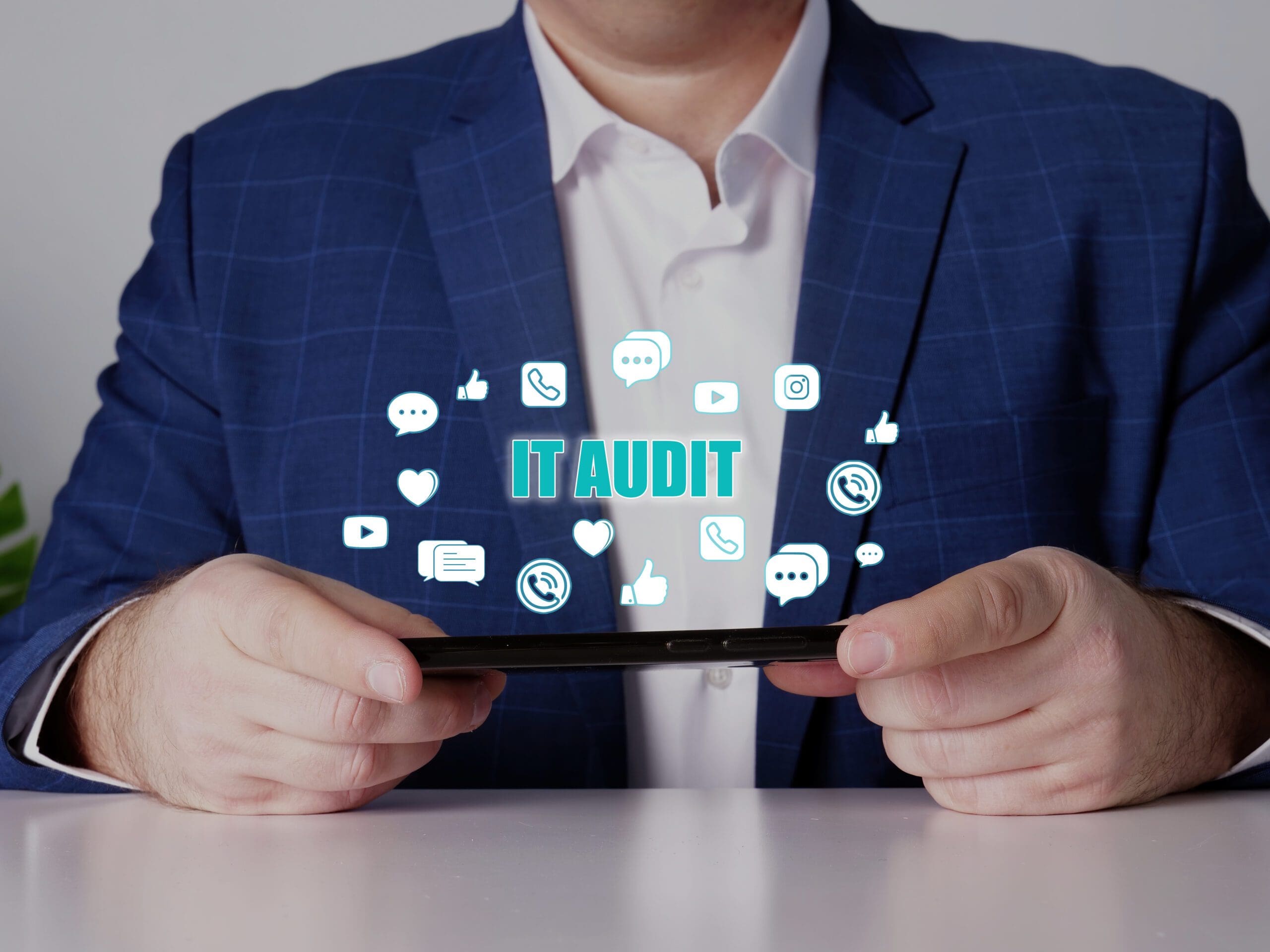 business man with tablet and cloud of IT icons above it with text IT audit