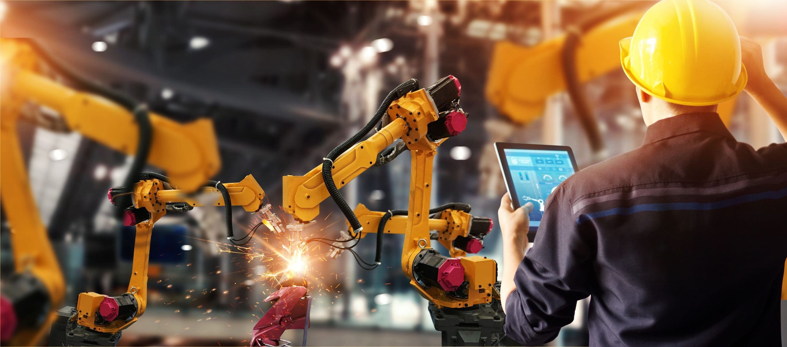 A worker looking at a tablet in a manufacturing plant