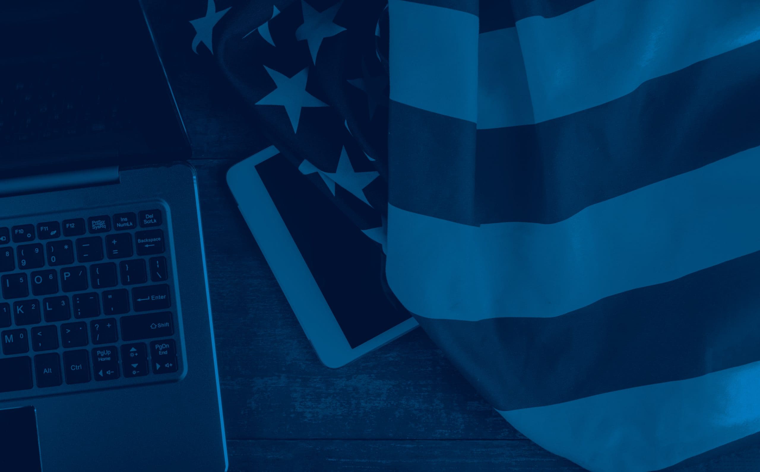 laptop and tablet on desk with American flag