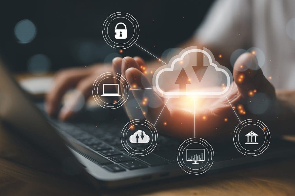 A person rests his wrist on a laptop with cloud icons superimposed on top.